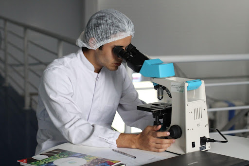  researcher looking into microscope